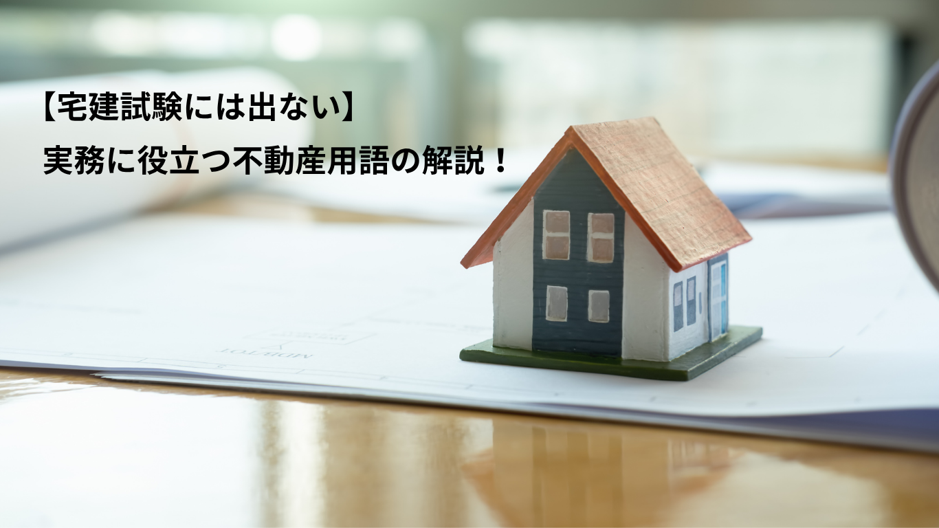 机上にある資料書類の上に、一戸建の小さな模型がある。その横に記事タイトルがレイアウト。